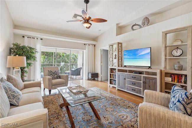 Living room with lofted ceiling, wood-type flooring, and ceiling fan | Image 6