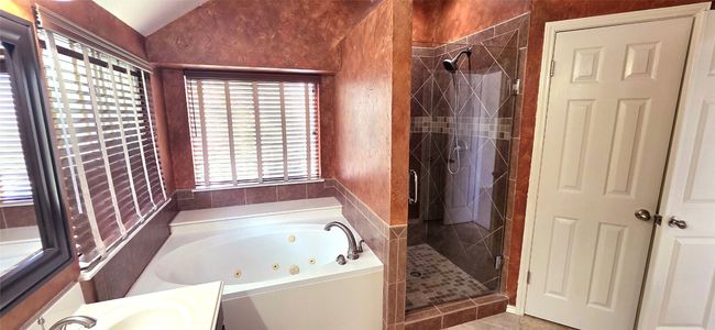 Full bathroom featuring a tub with jets, a shower stall, vanity, and lofted ceiling | Image 16
