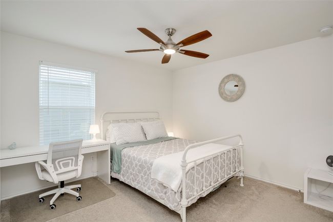 Carpeted bedroom featuring a ceiling fan and a desk | Image 16