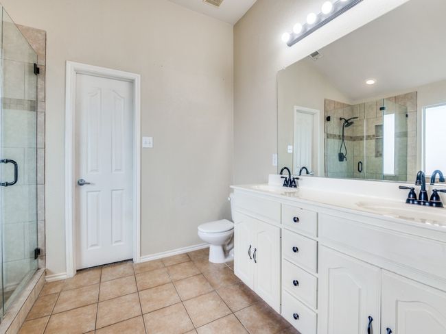 Bathroom with lofted ceiling, tile patterned floors, a stall shower, and a sink | Image 23