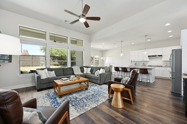 Step into the bright and airy living room, featuring high ceilings, large windows, and an open-concept design that seamlessly connects to the dining area and kitchen. | Image 8