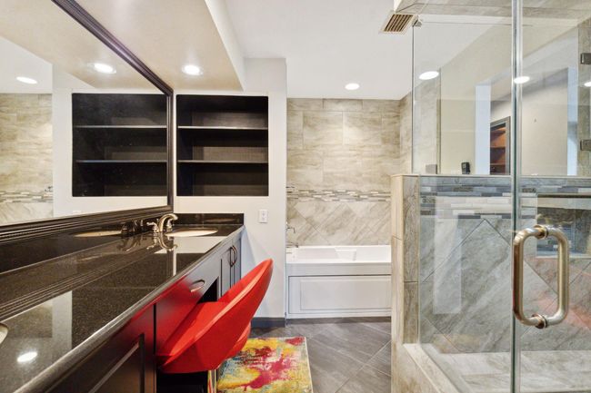 Modern, primary bathroom featuring a large walk-in shower with glass enclosure, double vanity with ample storage, and stylish fixtures. | Image 25