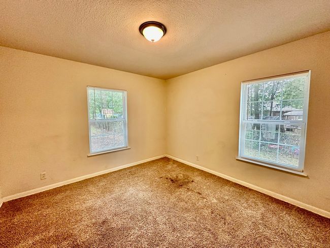 Carpeted spare room featuring a textured ceiling and baseboards | Image 7