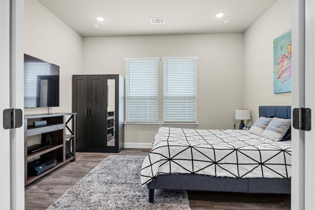 Bedroom with wood finished floors and recessed lighting | Image 16
