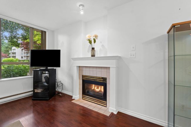 Living room featuring wood finished floors, a tile fireplace, and baseboards | Image 5