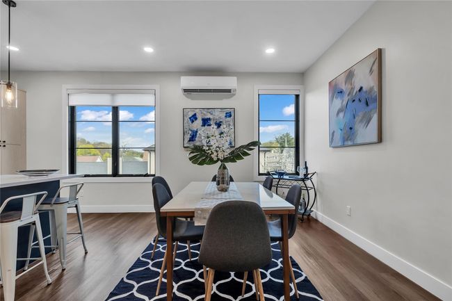 Dining area with an AC wall unit, dark wood-style flooring, baseboards, and recessed lighting | Image 13