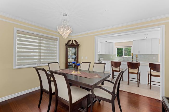 Dining room featuring a chandelier, dark wood-style floors, and ornamental molding | Image 7