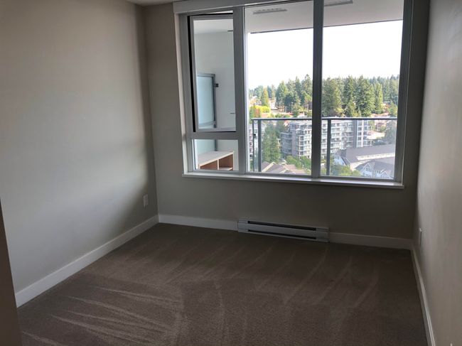 Unfurnished room with baseboard heating, dark colored carpet, and baseboards | Image 11
