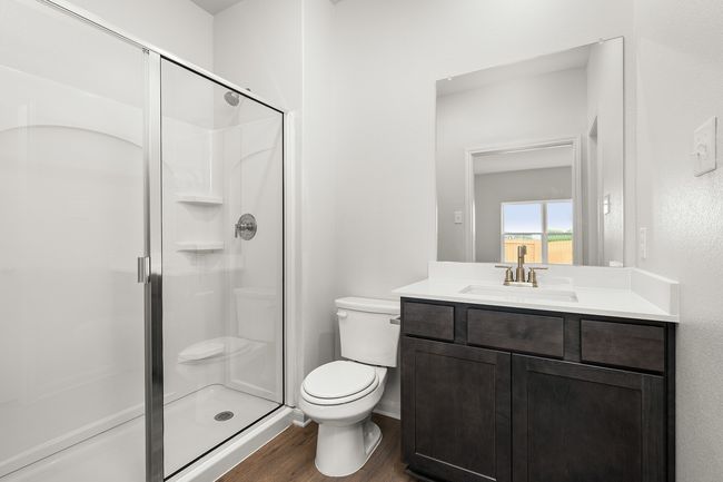 Full bath with a shower stall, vanity, and wood finished floors | Image 5