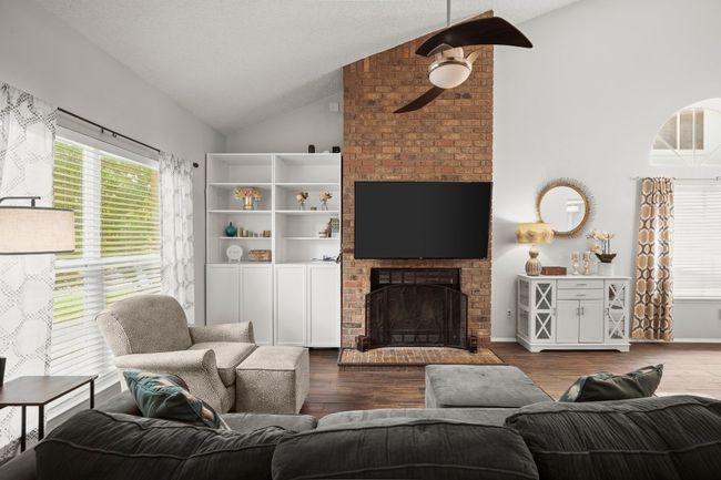 A massive floor-to-ceiling brick fireplace anchors the room, surrounded by custom built-ins that give you room to showcase your personality, while adding warmth and texture to the space | Image 5