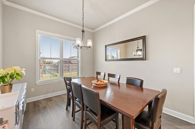 Dining room featuring crown molding, baseboards, a chandelier, and dark wood-style floors | Image 9