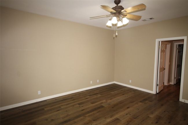 Spare room featuring dark wood-style floors and a ceiling fan | Image 12
