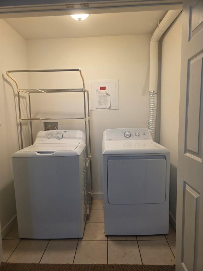 Clothes washing area featuring laundry area, washing machine and clothes dryer, and light tile patterned floors | Image 9