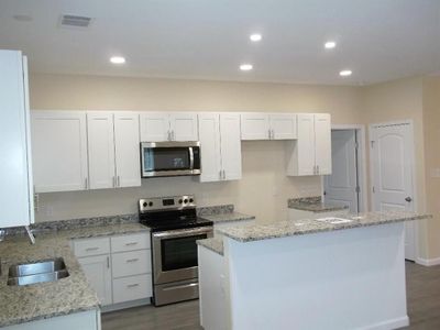 View from dinning area showing breakfast island, pantry, living room & office at front door | Image 1