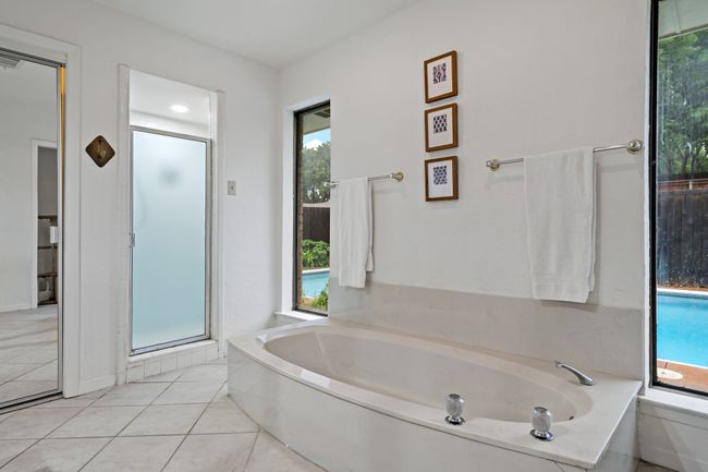 Bathroom with tile floors, a shower stall, a healthy amount of sunlight, and a garden tub | Image 10