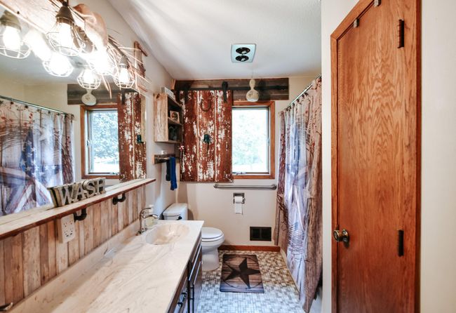 Unique window treatment is a sliding barn door style privacy barrier. Bathroom with lots of storage and a full shower/tub combo. | Image 15