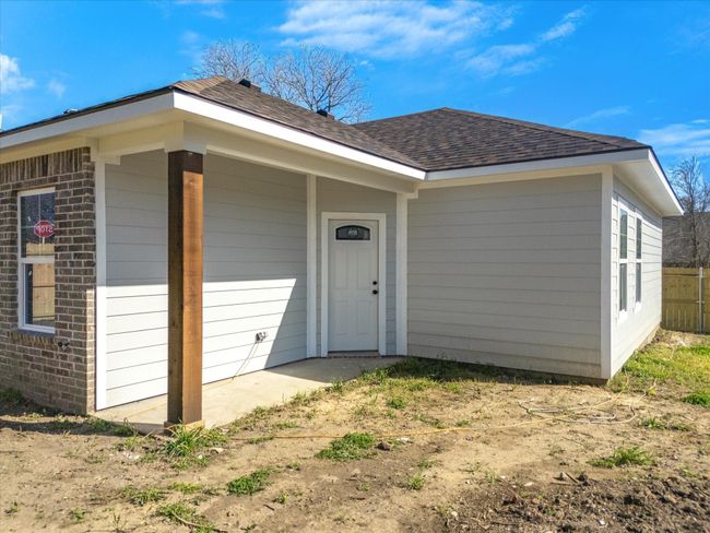Doorway to property featuring fence, brick siding, and a shingled roof | Image 34
