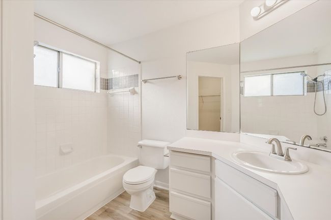 Bathroom with healthy amount of natural light, vanity, tub / shower combination, and wood finished floors | Image 9