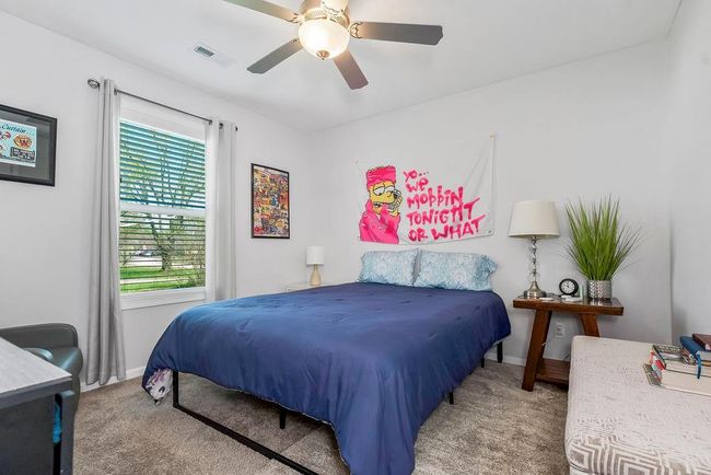 Carpeted bedroom featuring ceiling fan, baseboards, and visible vents | Image 24