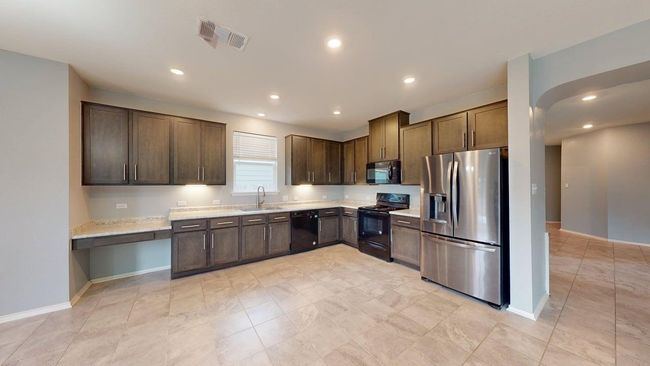 Kitchen featuring a sink, baseboards, black appliances, and visible vents | Image 15