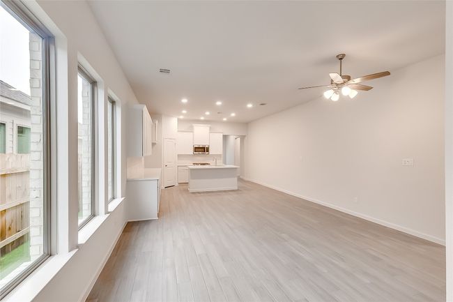 Unfurnished living room featuring light wood-type flooring, ceiling fan, baseboards, and recessed lighting | Image 5