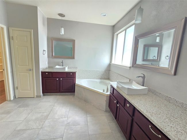 Bathroom featuring a bath, two vanities, and tile patterned flooring | Image 18