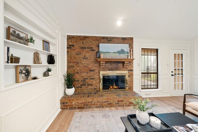 Living area with built in features, a fireplace, and LVP floors | Image 9