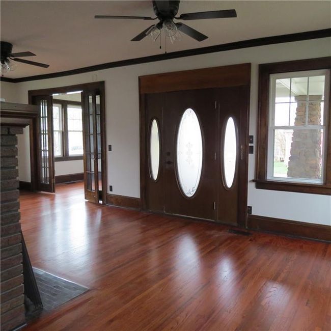 Entryway featuring baseboards, wood finished floors, ceiling fan, and crown molding | Image 24