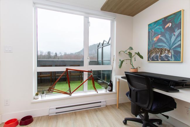 Home office featuring a baseboard heating unit, a wealth of natural light, and light wood-style flooring | Image 9