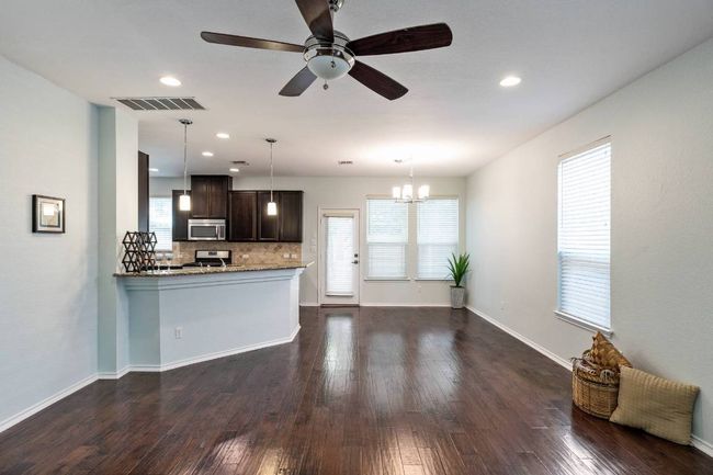 Kitchen with stainless steel microwave, dark brown cabinets, decorative backsplash, dark wood-style floors, and recessed lighting | Image 20