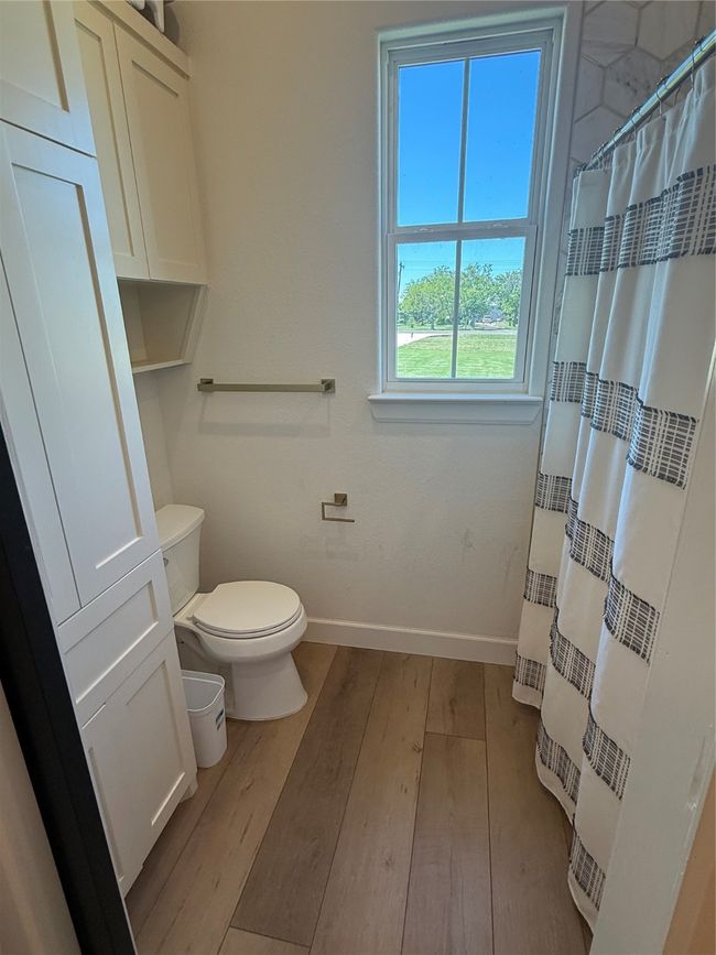 Full bathroom with wood finished floors and a shower with curtain | Image 11