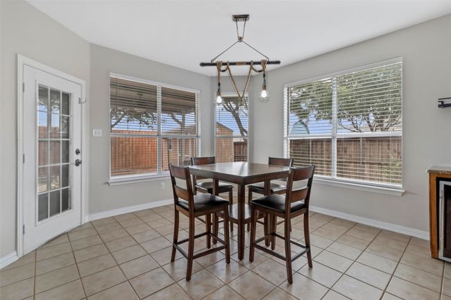 Dining space with healthy amount of natural light and light tile patterned floors | Image 12