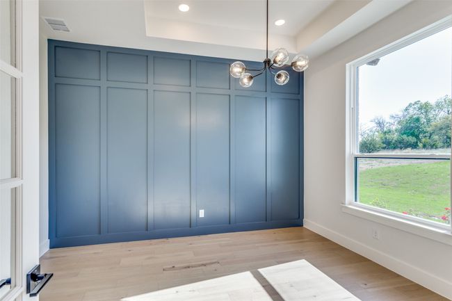 Unfurnished dining area with visible vents, baseboards, an inviting chandelier, a decorative wall, and light wood-style floors | Image 11