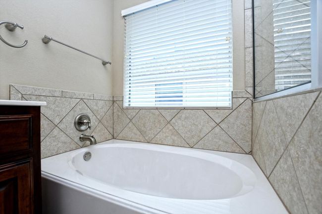 Bathroom featuring a bath, plenty of natural light, and vanity | Image 22