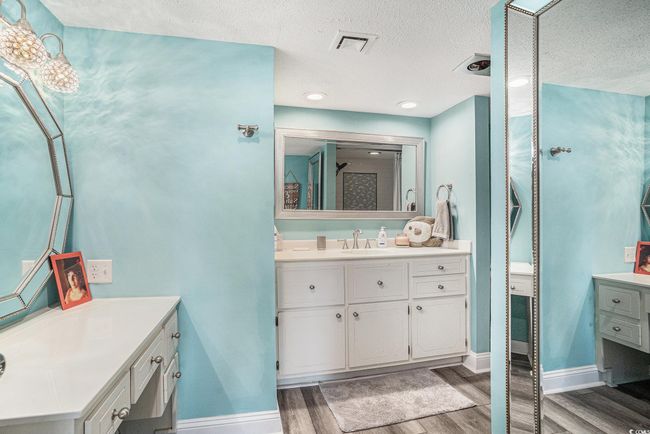 Bathroom with wood finished floors, two vanities, and a textured ceiling | Image 17