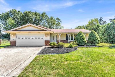 Ranch-style home with a garage, covered porch, and a front lawn | Image 1