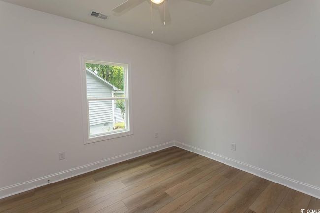 Spare room with wood finished floors, baseboards, and ceiling fan | Image 12