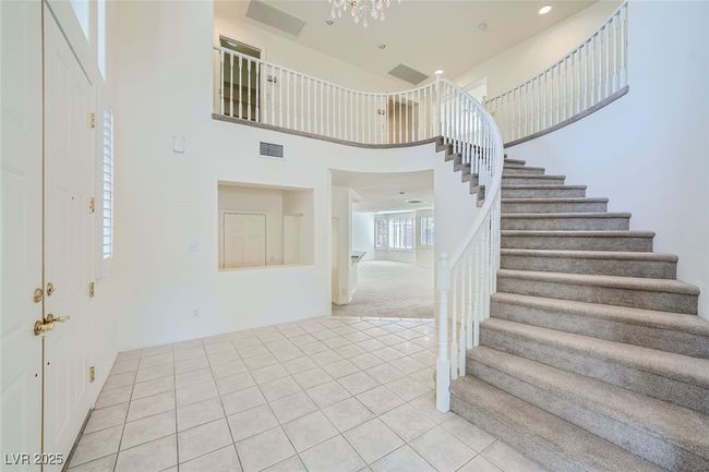 Entrance foyer featuring light tile patterned floors, recessed lighting, a high ceiling, visible vents, and stairs | Image 21