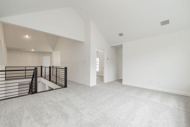 Unfurnished room featuring carpet, high vaulted ceiling, and baseboards | Image 10