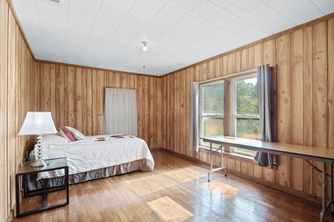 Bedroom featuring crown molding, wooden walls, and wood-type flooring | Image 18