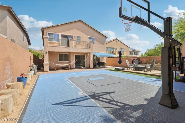 View of sport court with basketball hoop and a fenced backyard | Image 66