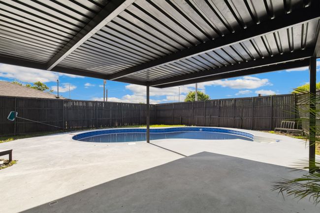 View of swimming pool featuring a fenced in pool, a patio, and a fenced backyard | Image 35