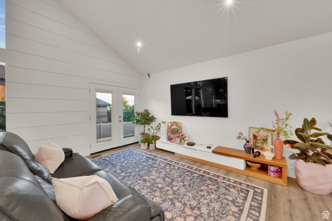 Living area featuring wood finished floors, french doors, high vaulted ceiling, and recessed lighting | Image 15