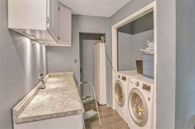 Clothes washing area with washing machine and dryer, light wood-style flooring, and laundry area | Image 15