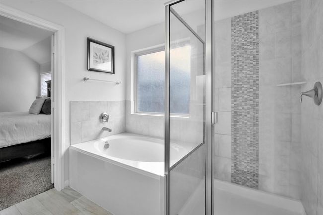 Full bathroom featuring ensuite bathroom, a bath, and a stall shower | Image 17