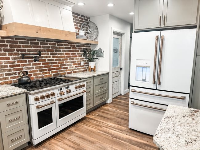 Kitchen featuring light stone counters, light wood-style floors, custom exhaust hood, and white appliances | Image 10