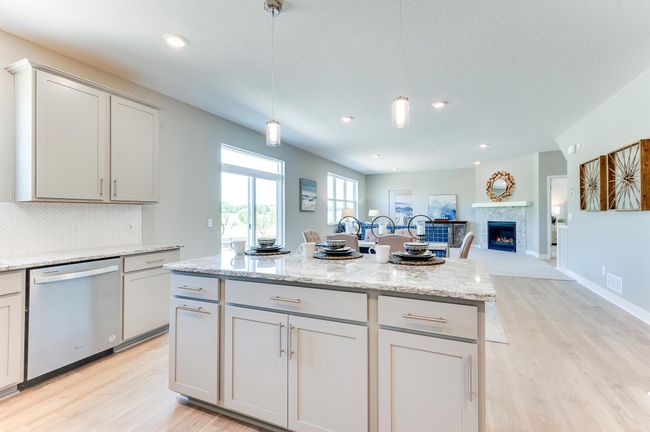 The rest of the main level pours out from the home's kitchen, as the layout flows seamlessly from the kitchen space into the dining and living areas! Photo of model home, color and options will vary. | Image 16