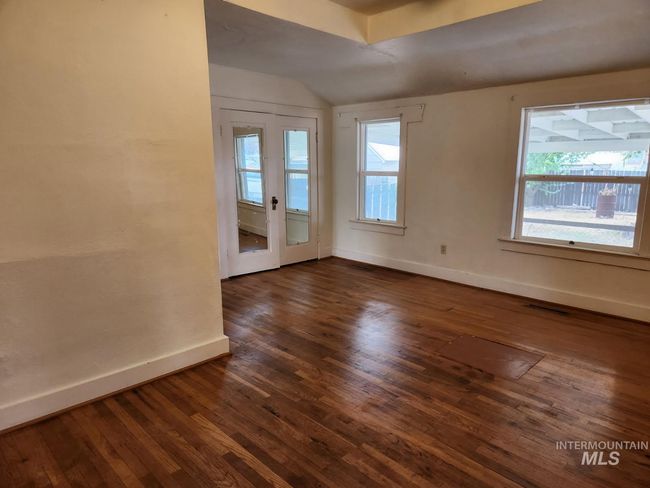 Unfurnished room featuring dark wood-type flooring, lofted ceiling, healthy amount of natural light, and french doors | Image 9