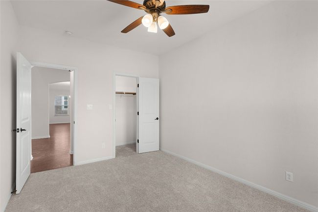 Unfurnished bedroom with light carpet, arched walkways, a ceiling fan, and baseboards | Image 18