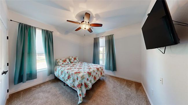 Bedroom featuring a ceiling fan, baseboards, and carpet | Image 41